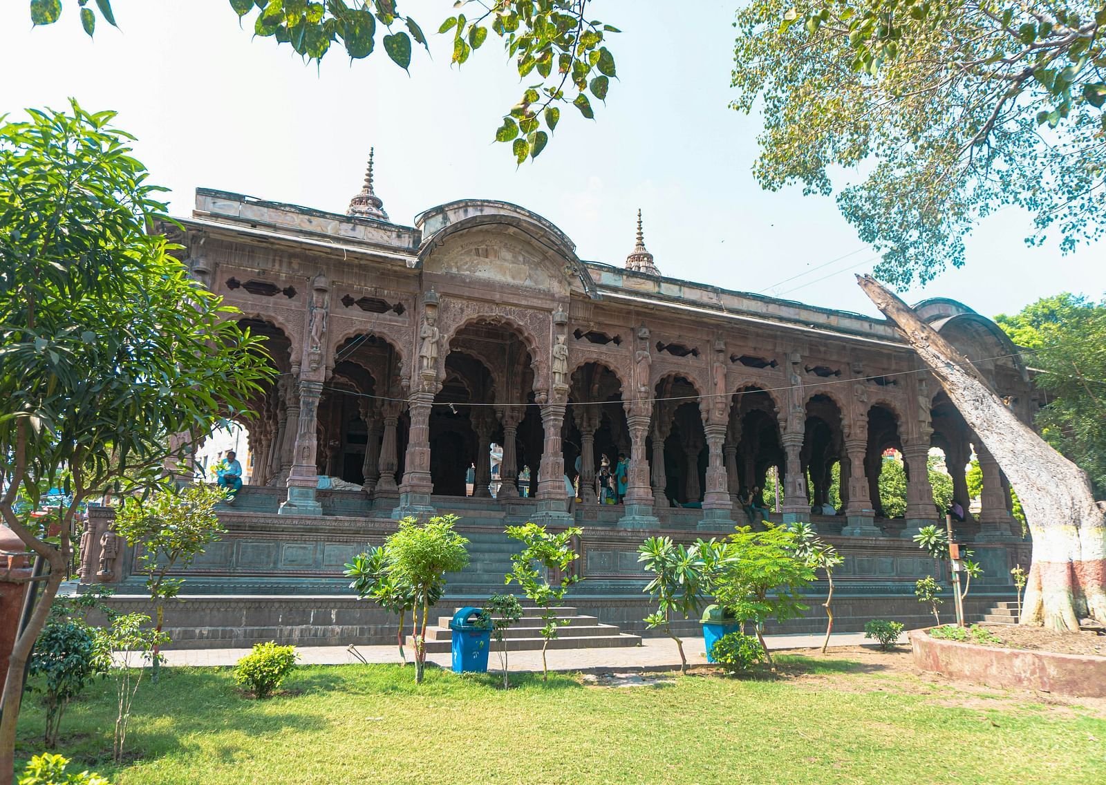 An overview of Rajwada palace in Indore with a garden and trees in front of it.