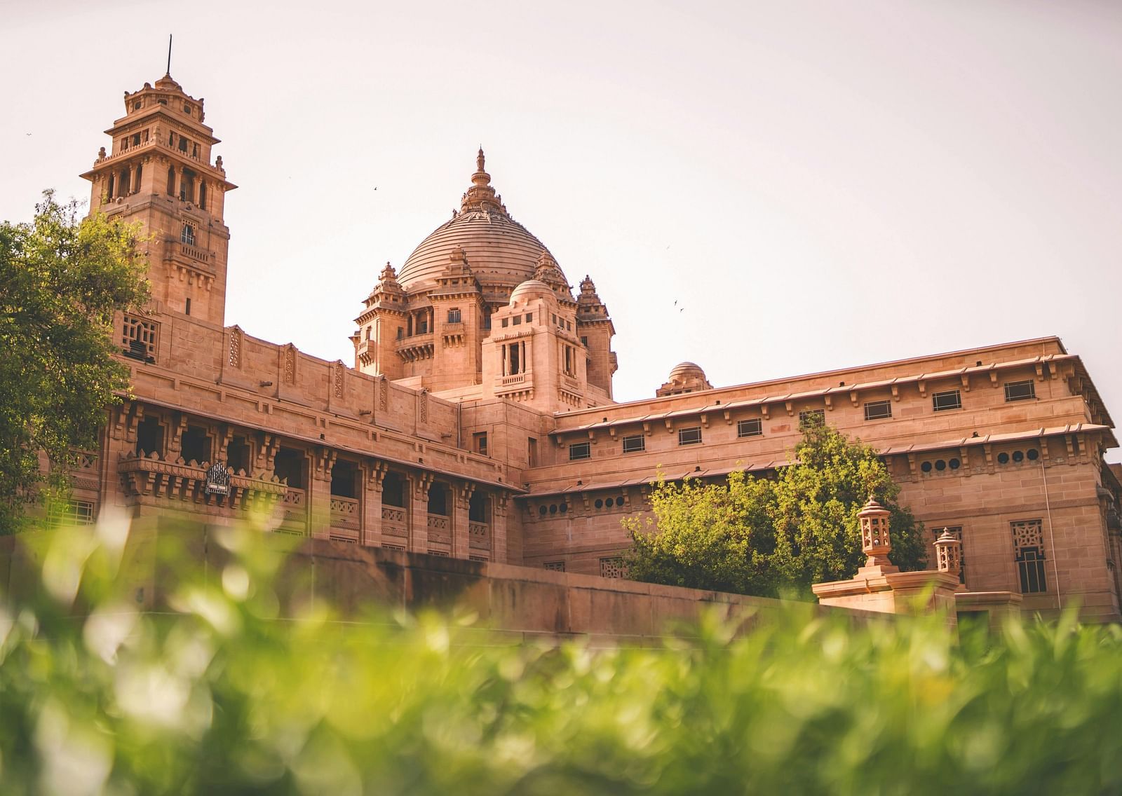 Exterior of a fort made of stone during the day with greenery in the foreground