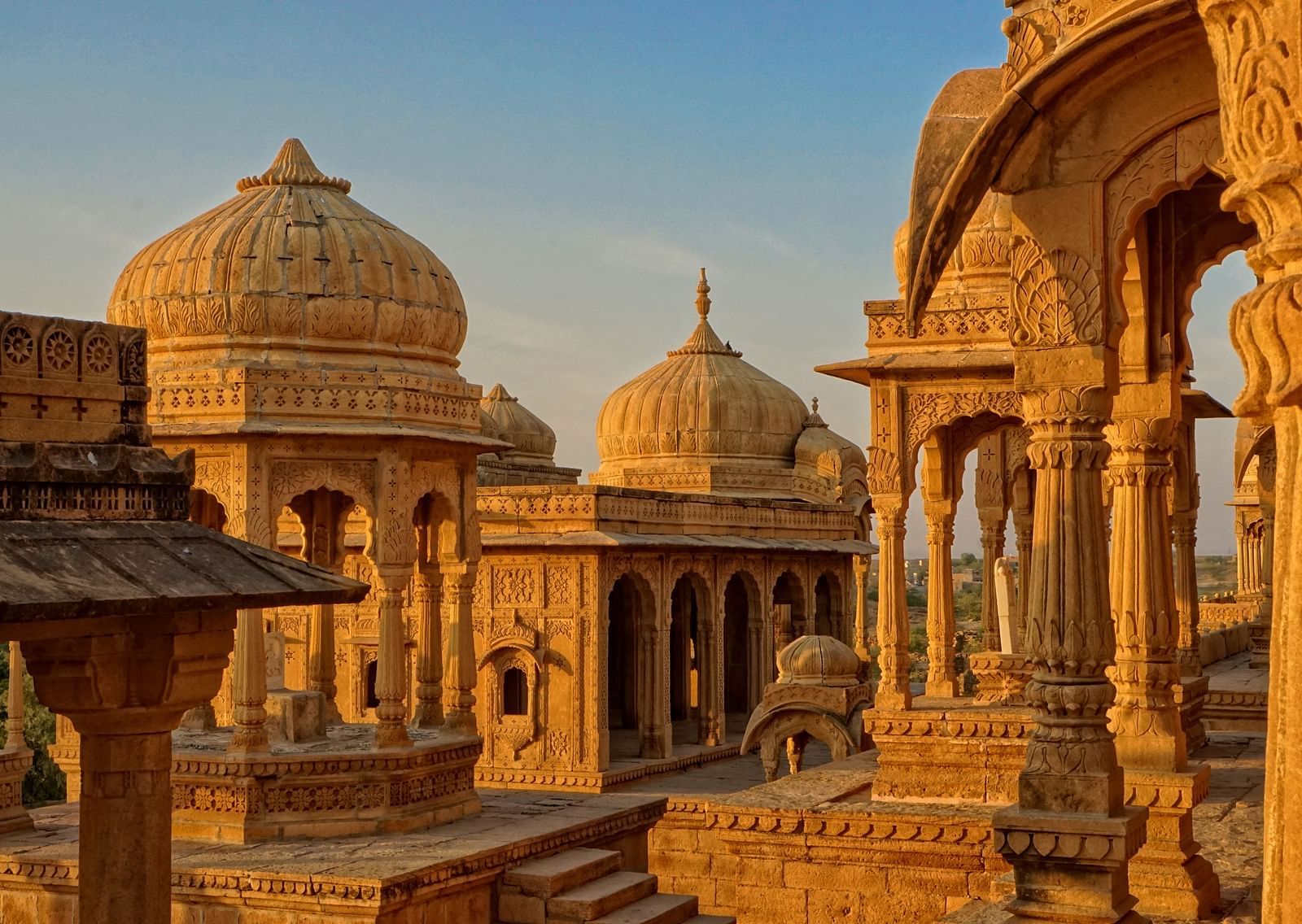 An overview of a temple with many domes on the buildings with sun shining down on them. - Fort in Indore