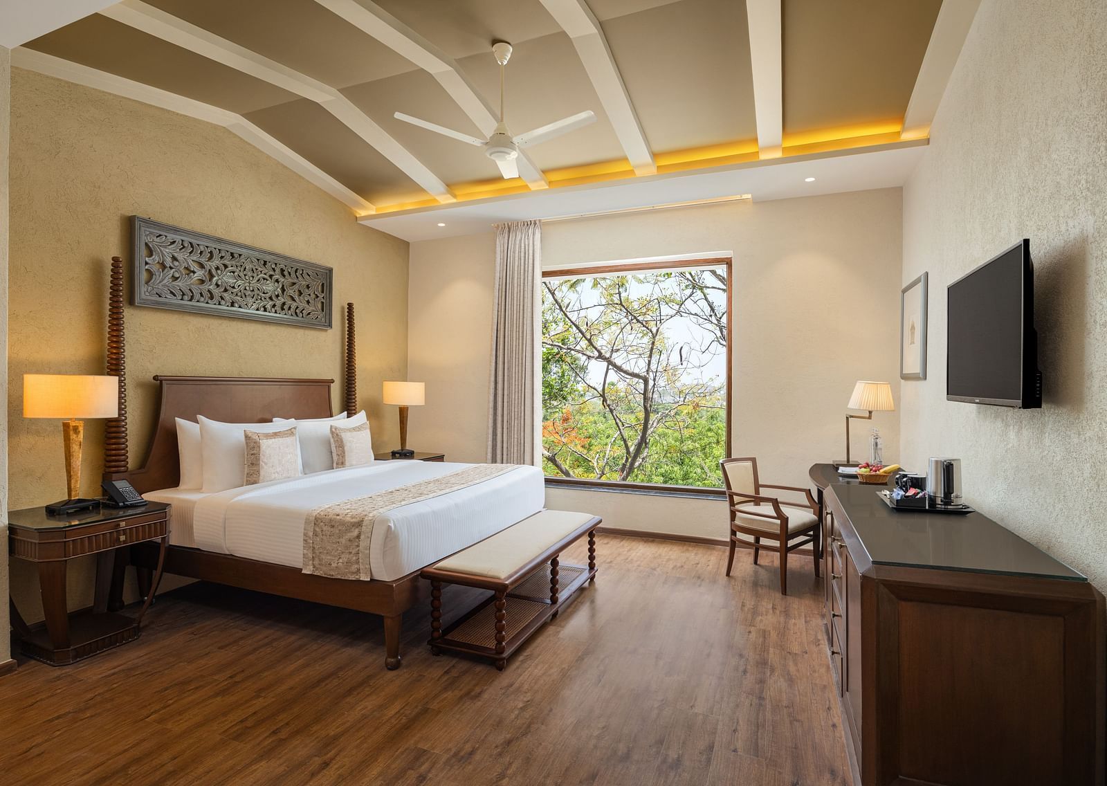 Deluxe room with a king size bed placed in front of a TV at Essentia Luxury Resort & Spa, Udaipur.