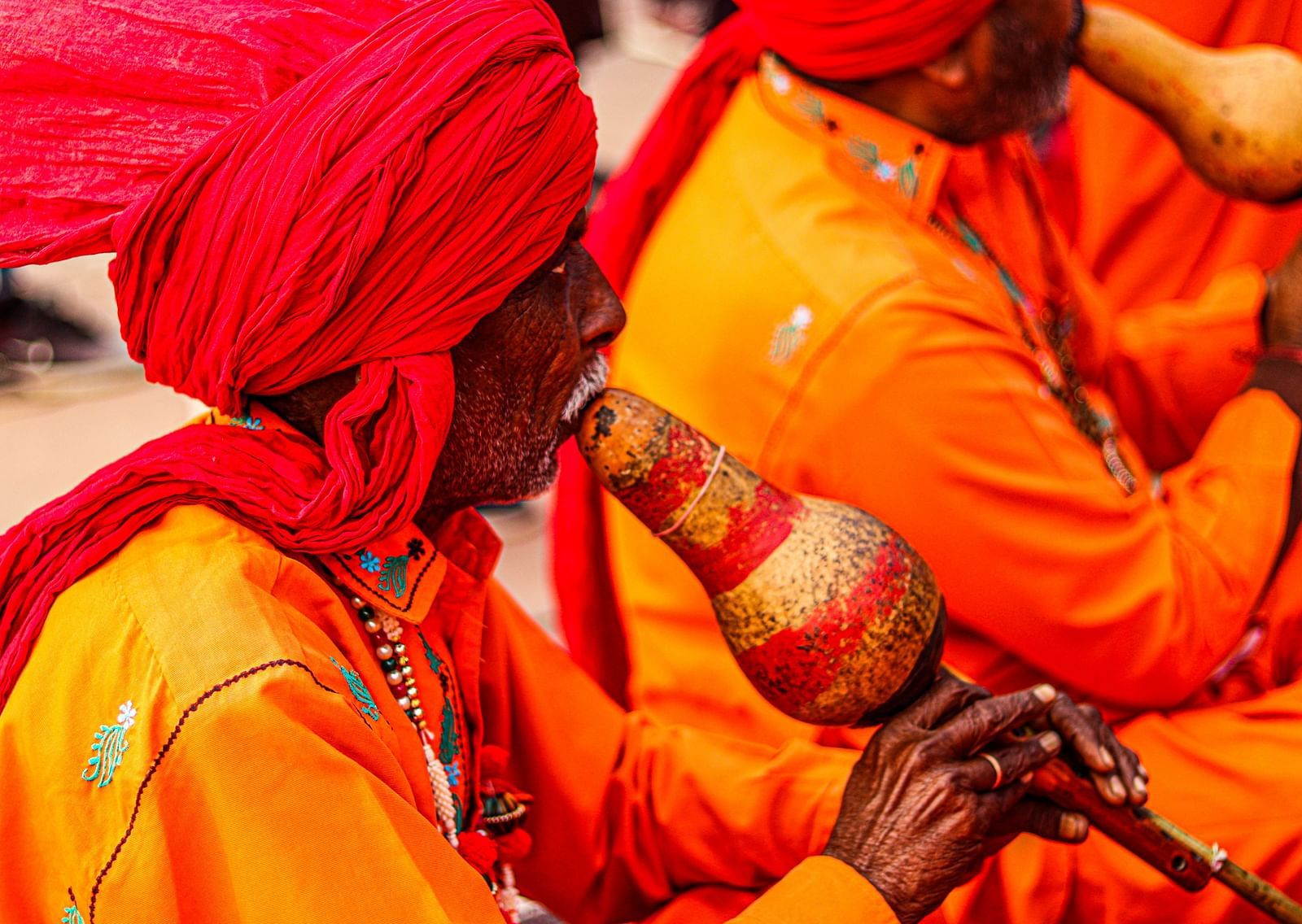 A group of older Rajasthani men playing a traditional music instrument.