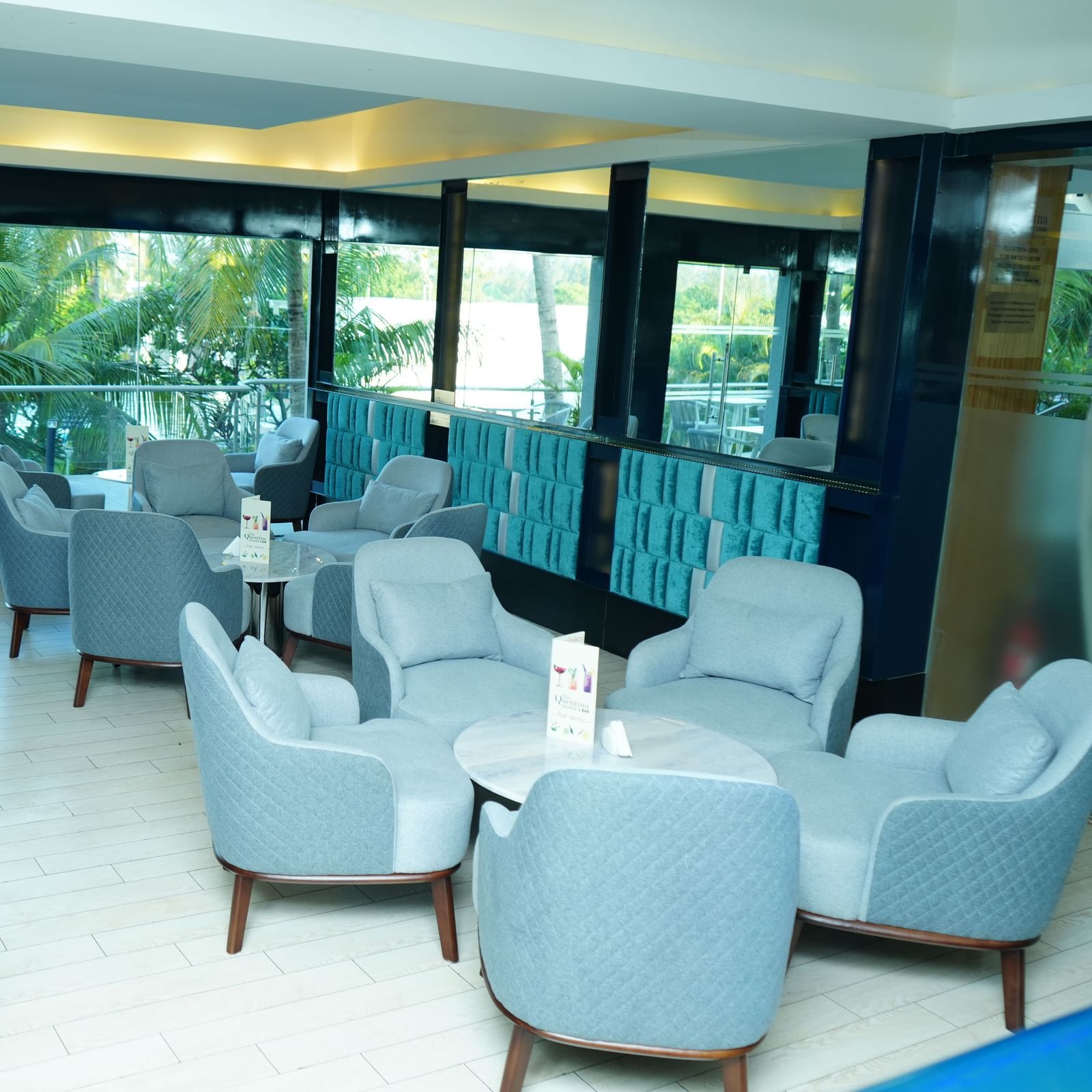 Lounge seating with armchairs and tables in a bright indoor space at Grande Bay Resort & Spa.