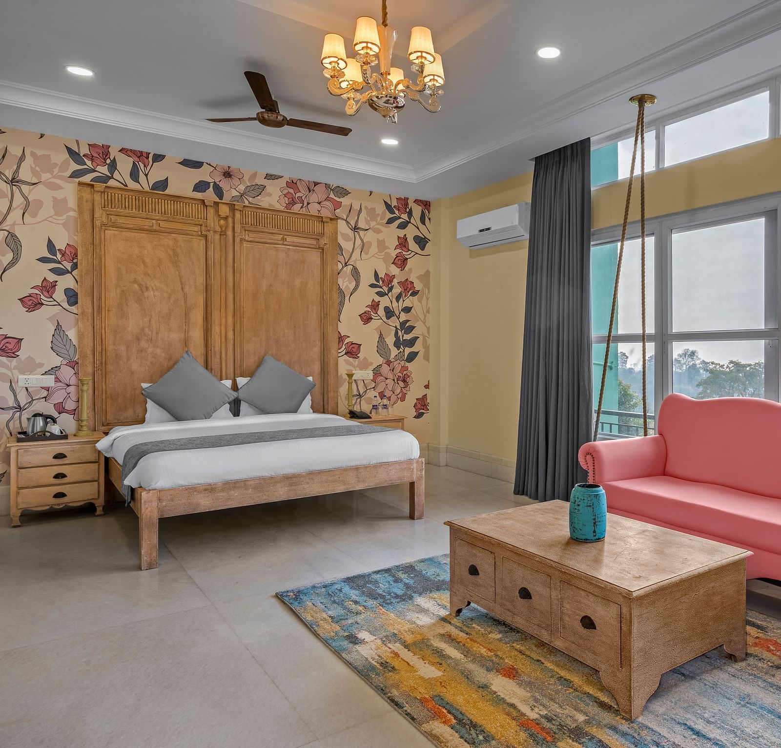An image featuring a spacious bedroom with a king-size bed, a sofa, and a large window with a view - atman, dharamshala