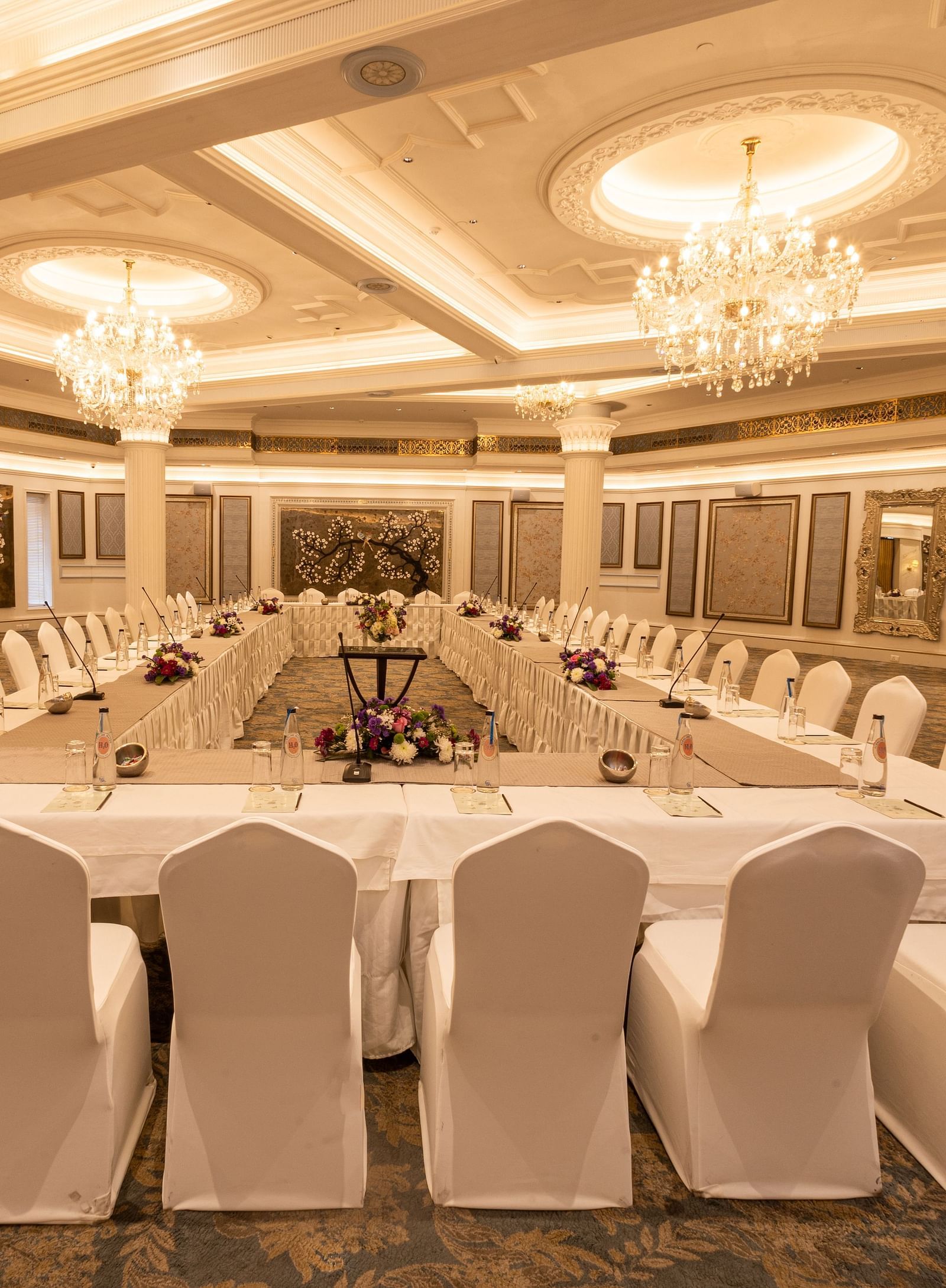 Image featuring the Viceroy Hall event venue at The Claridges New Delhi, showcasing seating arrangements and an elegant chandelier hanging overhead