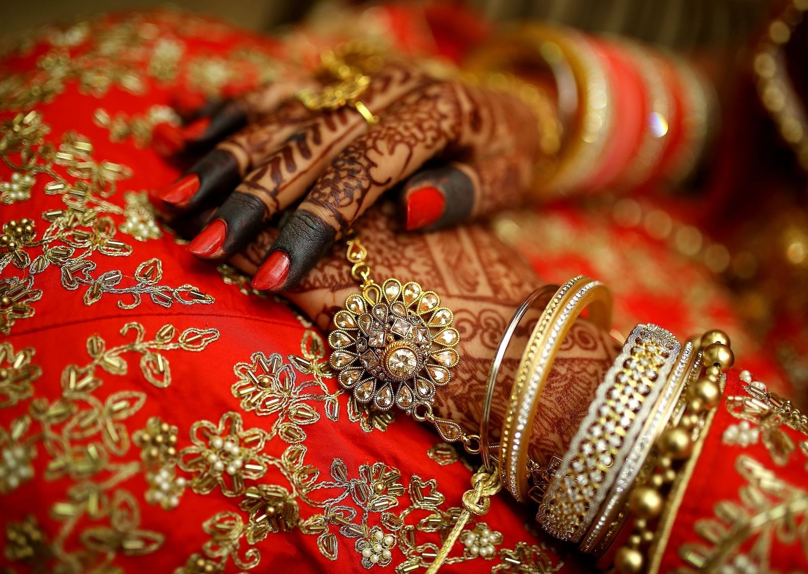 A close-up of a woman's hands adorned with intricate henna designs