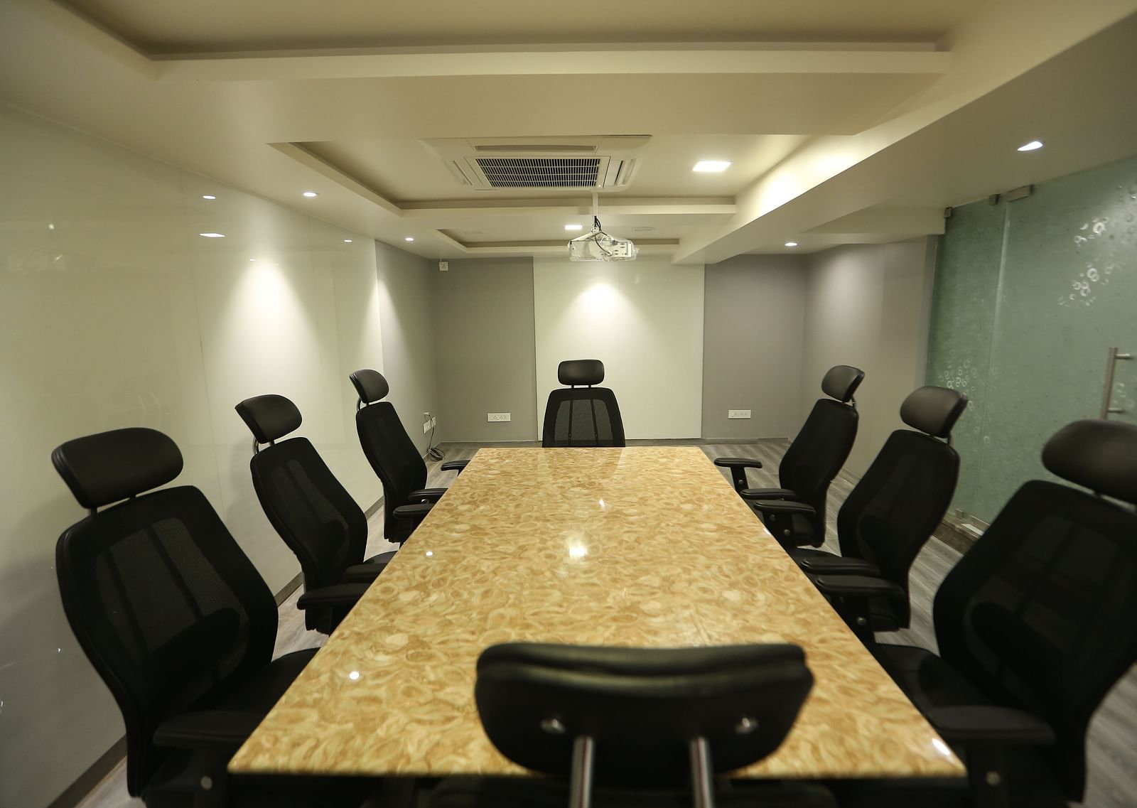 A close-up of a meeting room table with chairs around a long table - TGI SPS Grand, Coimbatore