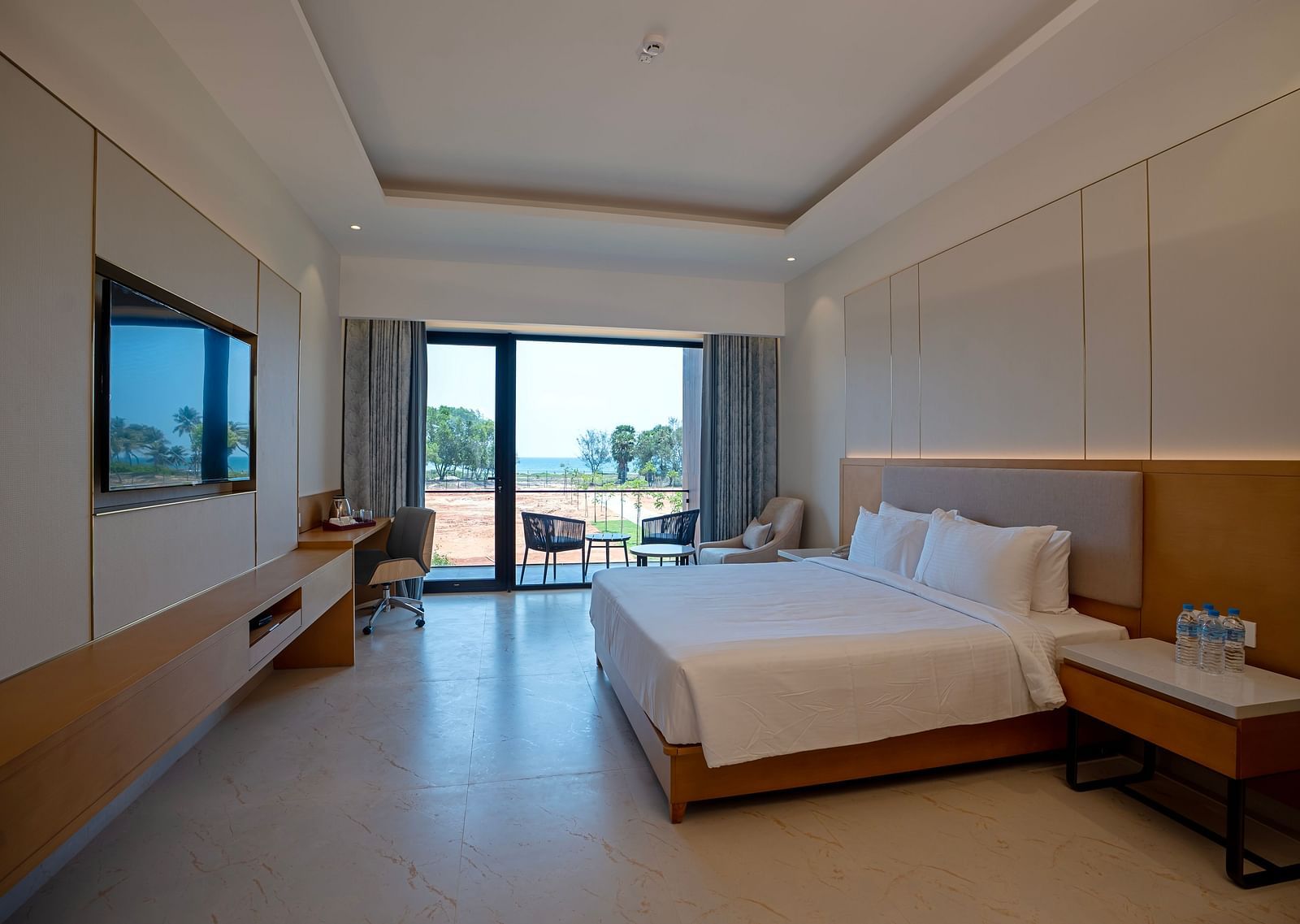 A spacious room of the Bay View Bliss at The Shore, Trishvam with ample of natural light coming from the french windows.