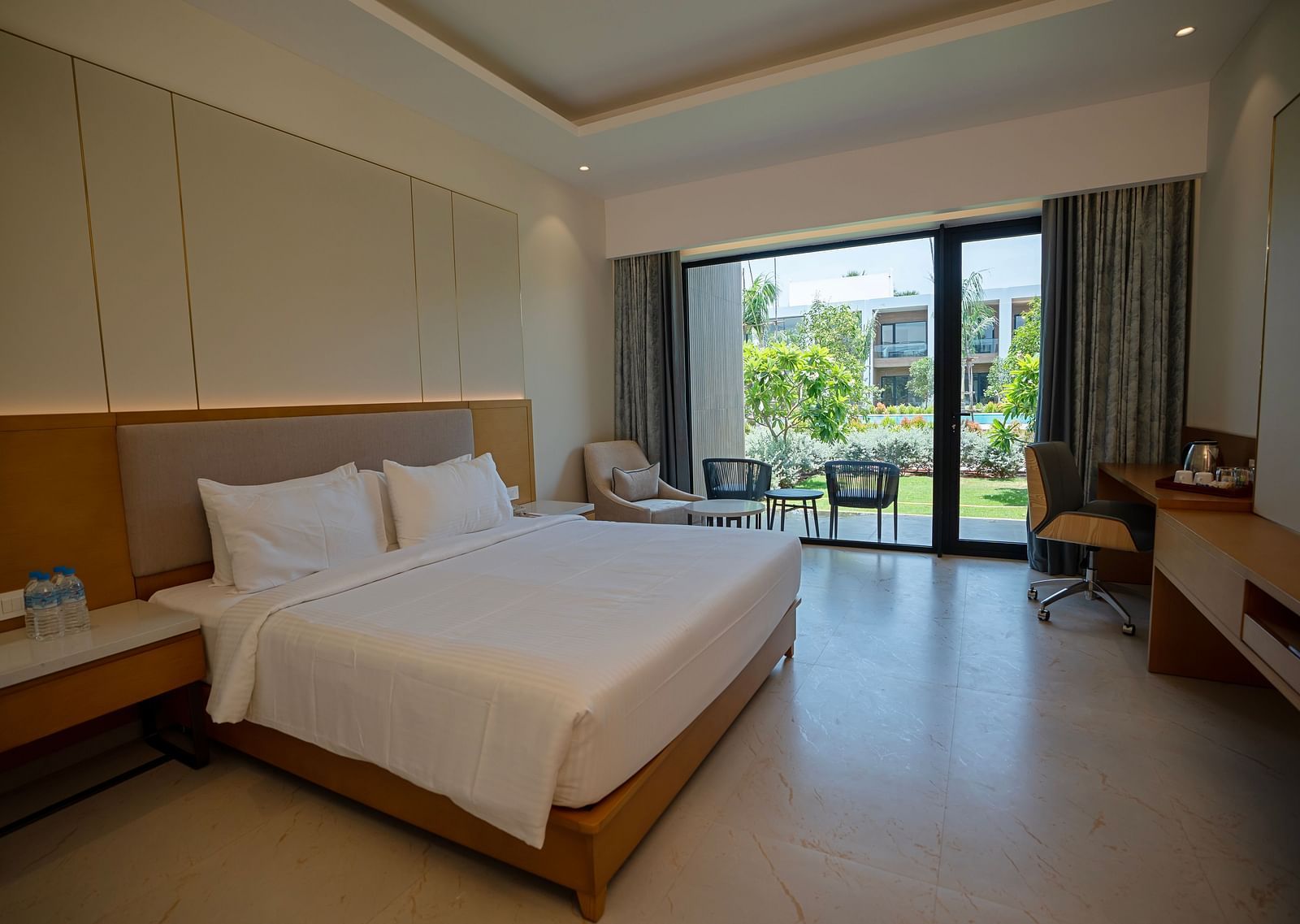 The Garden Courtyard room with huge french windows in the corner of the room at The Shore, Trishvam.