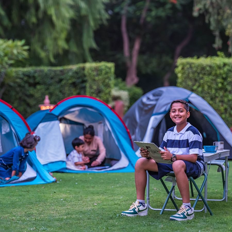 children playing in tents in the lush garden at Heritage Village Resort & Spa, Manesar