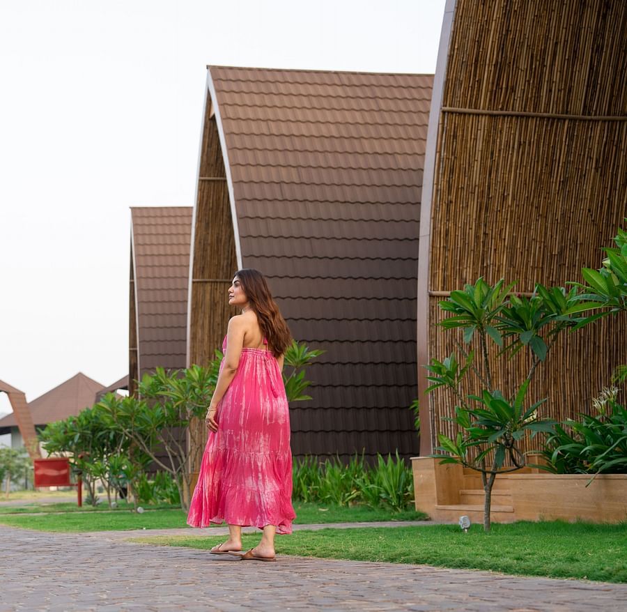 Woman walking through a pathway near an array of villas at Ananta Spa and Resort, Ajabgarh.