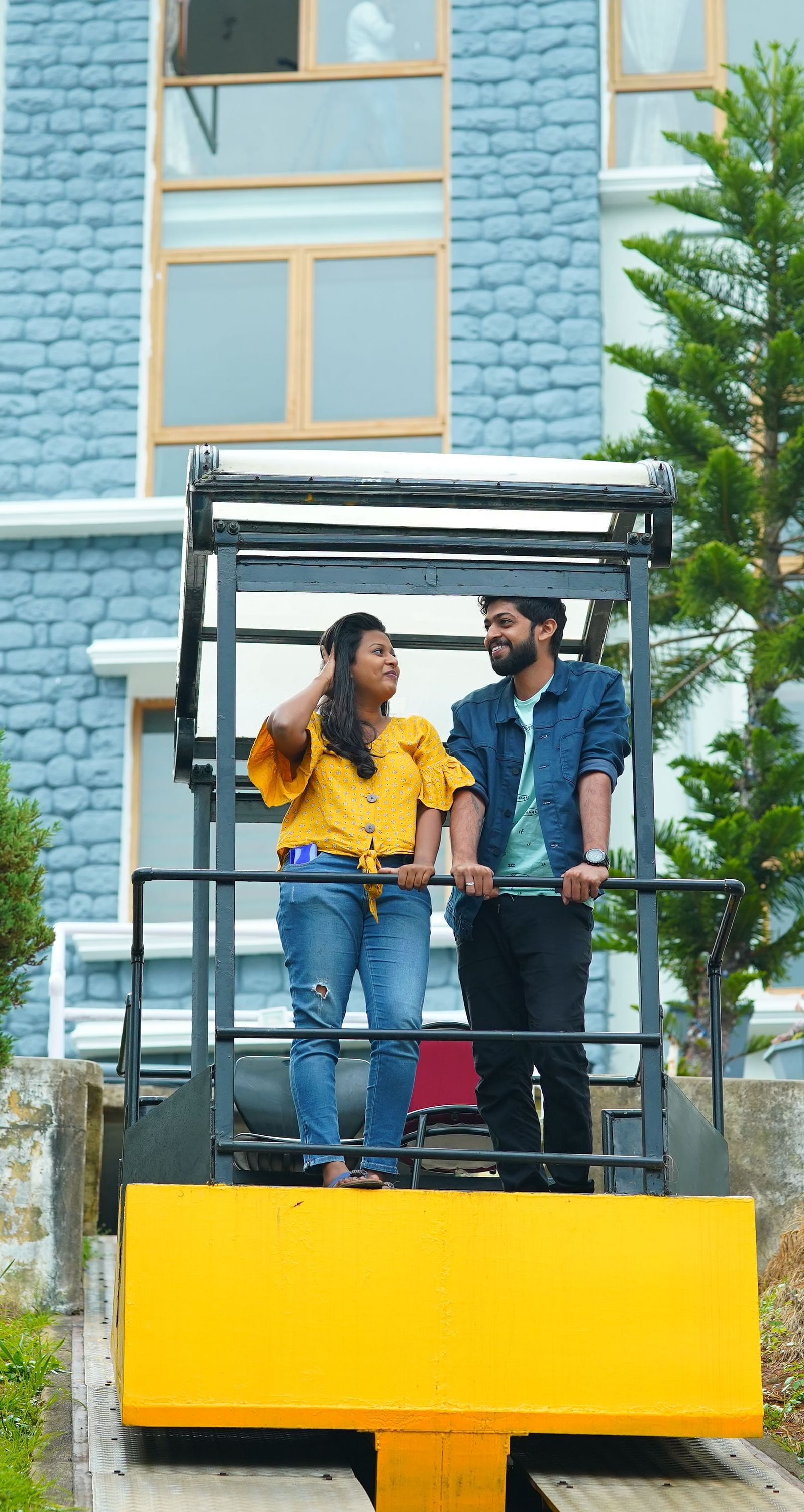 a man and woman standing on a yellow platform at La Montana By TGI, Ooty