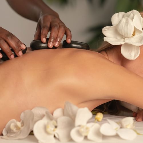 a woman getting a hot stone massage at a spa