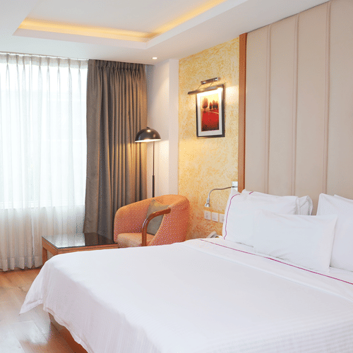 Comfortable standard room at Nemesia with a bed setup, a work desk, and a seating area.