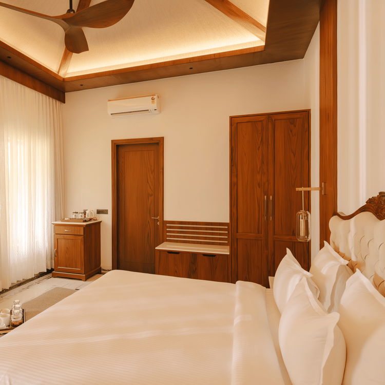 Comfortable bed facing a TV above a cabinet at The Ananta Udaipur.