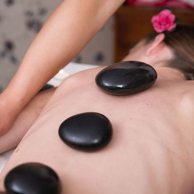 spa treatment involving stones kept on a person