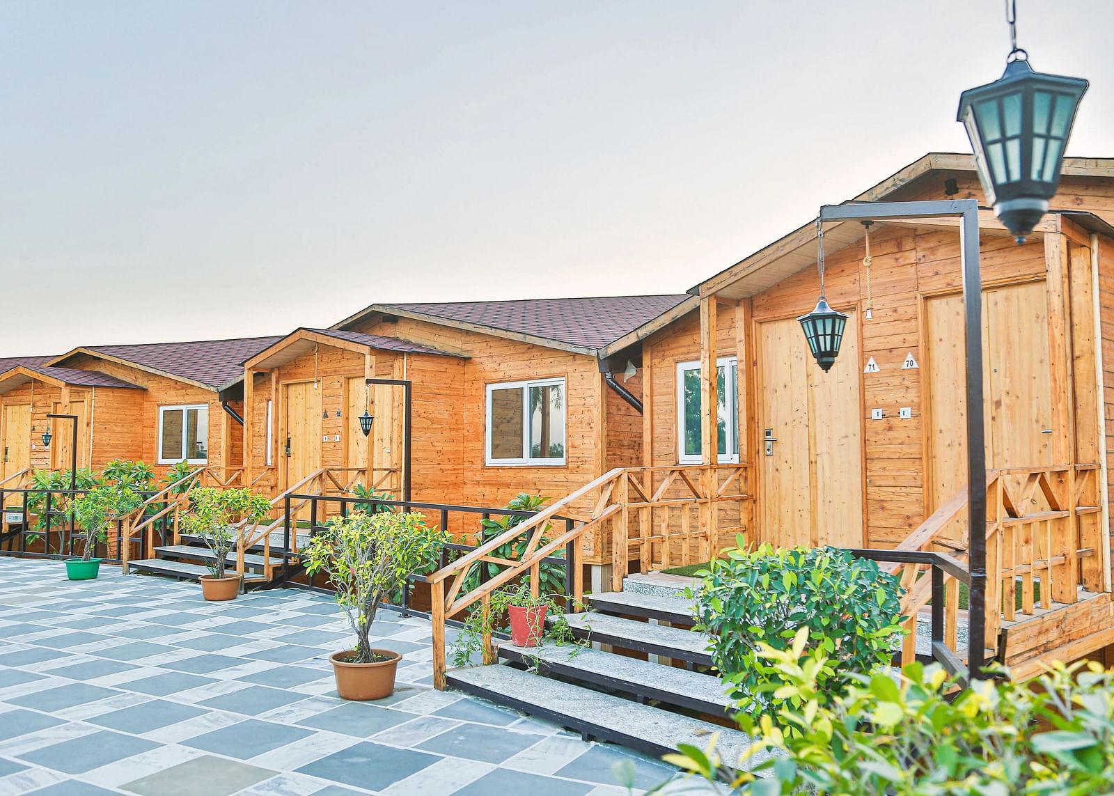 A row of small wooden cabins with green trim.