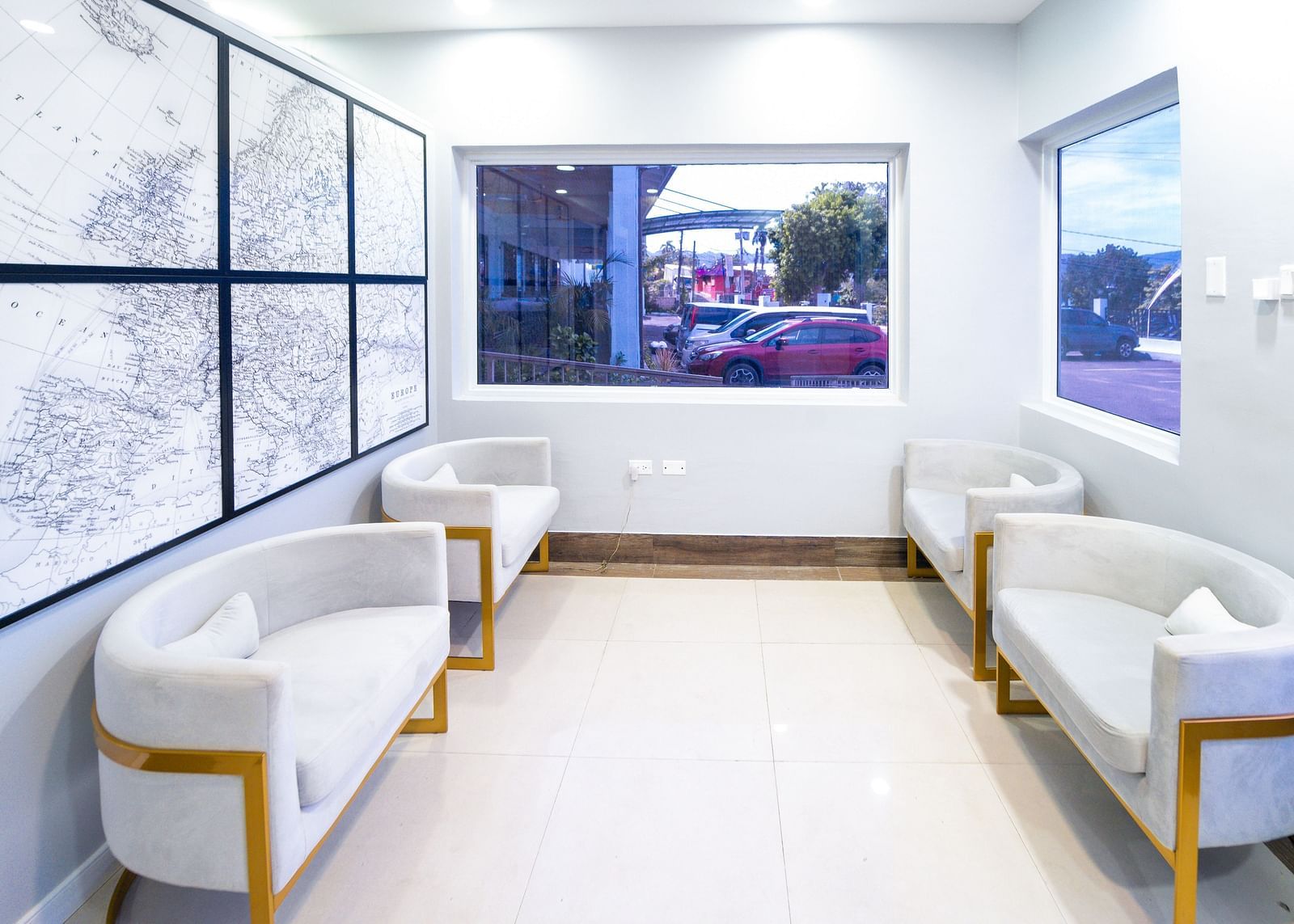 An image of a travel agency with white sofas and a wall-mounted representing the world map - Hotel 39, Jamaica (Montego Bay)