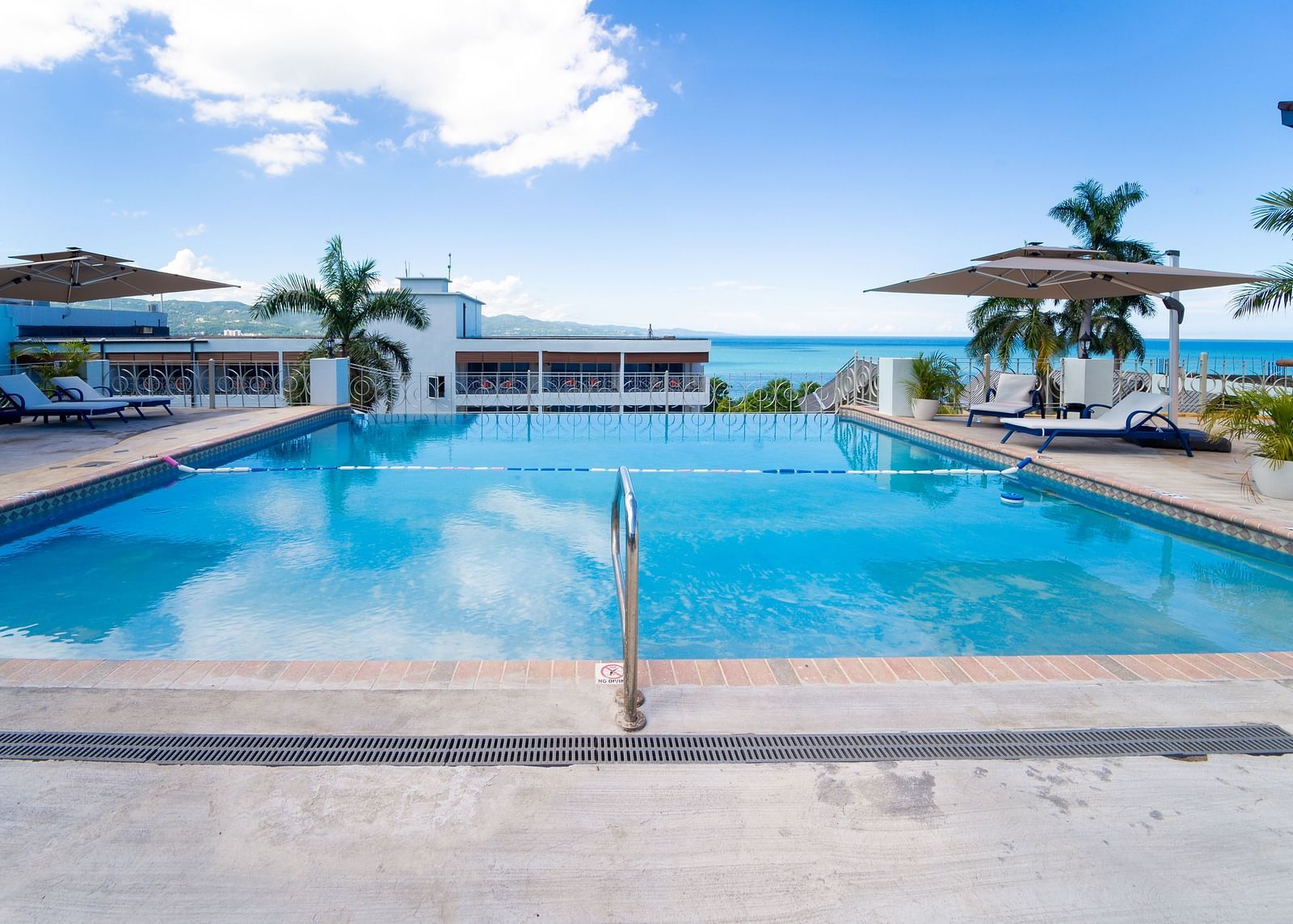 A close up shot of a pool with clear water and views of Montego Bay in the background - Hotel 39, Jamaica (Montego Bay)