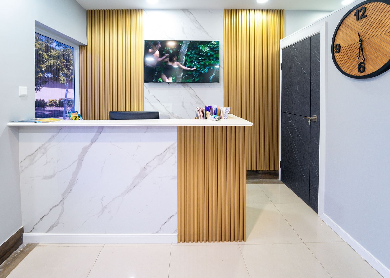 An image of a reception desk in a travel agency with a wall-mounted clock on the side - Hotel 39, Jamaica (Montego Bay)