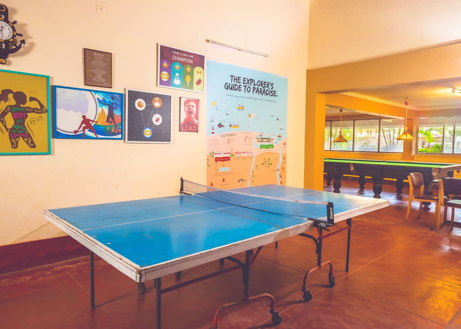 A view of a table tennis table in the game room at Paradise Isle Beach Resort, Udupi with a snooker table visible in the backdrop