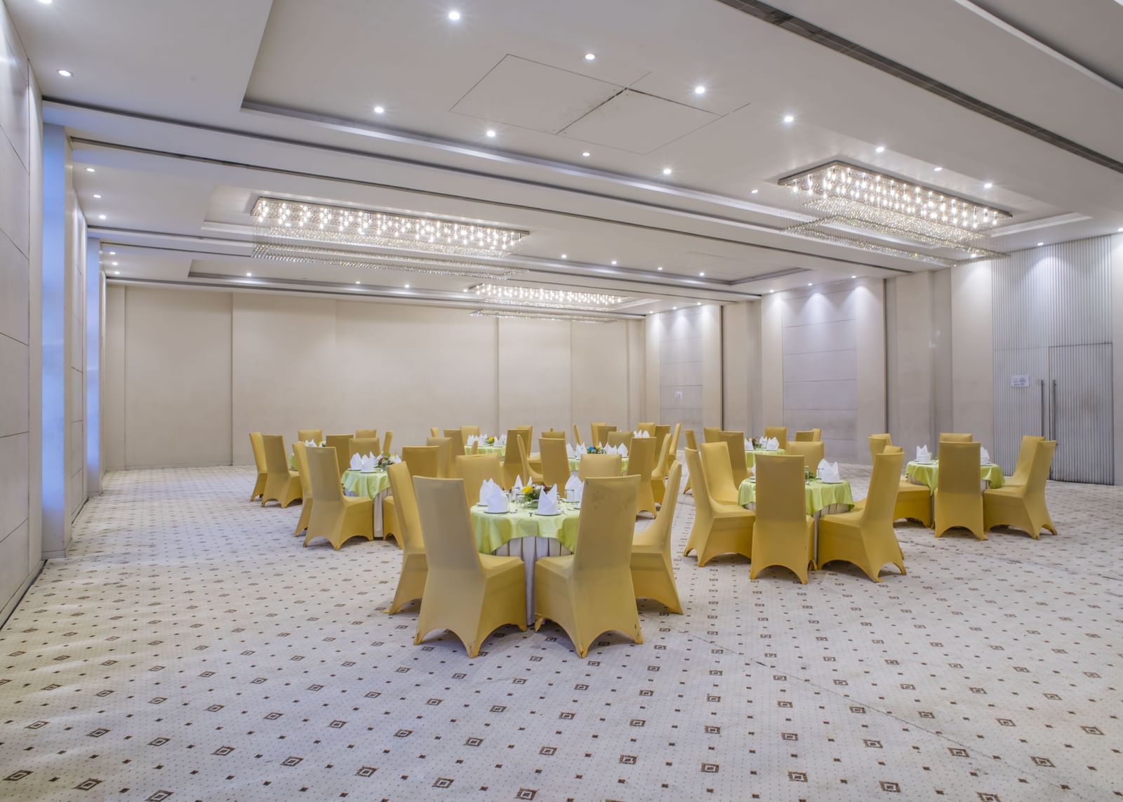 A meeting room with cluster seating arrangements of yellow chairs at The Citi Residenci Hotel, Asansol.