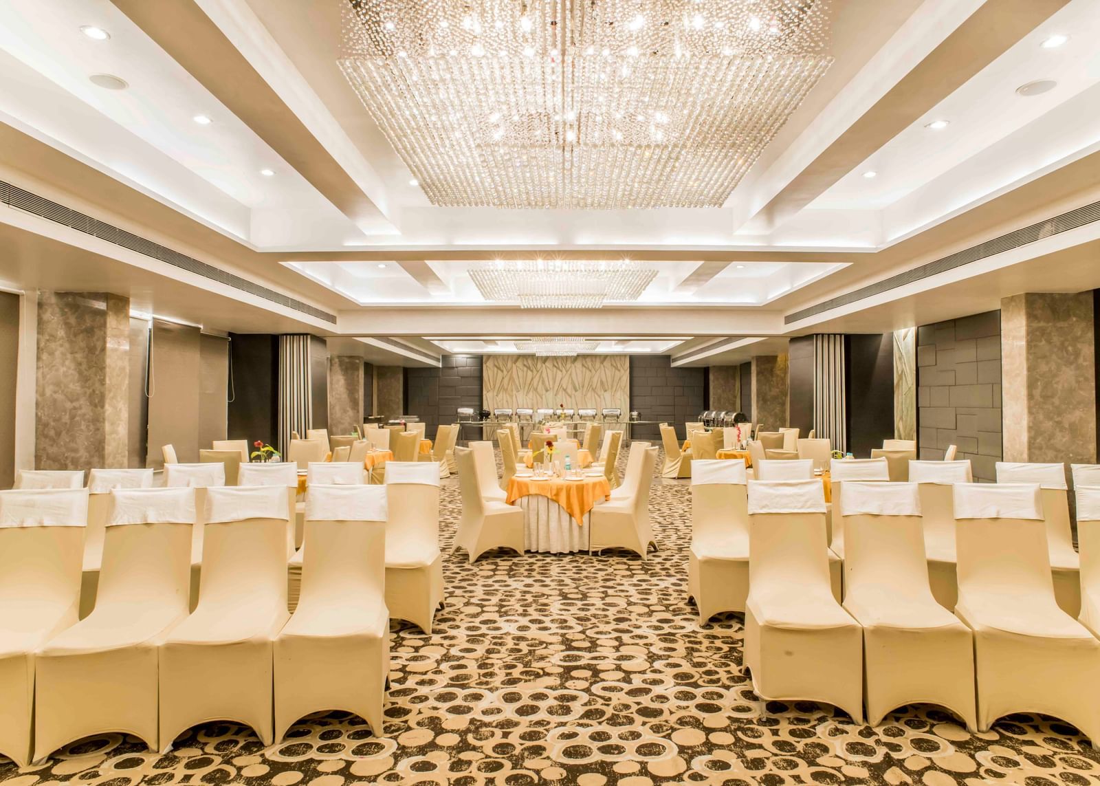 A wide view of a banquet hall with neatly arranged tables and chairs at The Citi Residenci Hotel, Durgapur.
