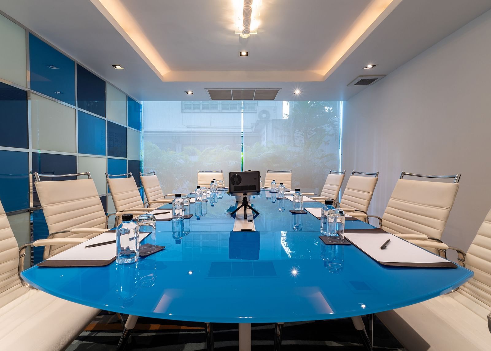 Seating arrangement inside a meeting room with white chairs and blue table - Night Hotel Bangkok