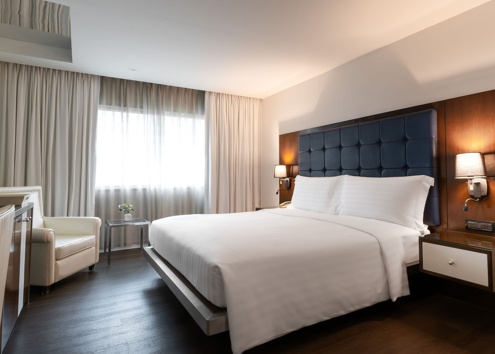 An overview of a double bed with lamps on the side inside one of the rooms - Night Hotel Bangkok