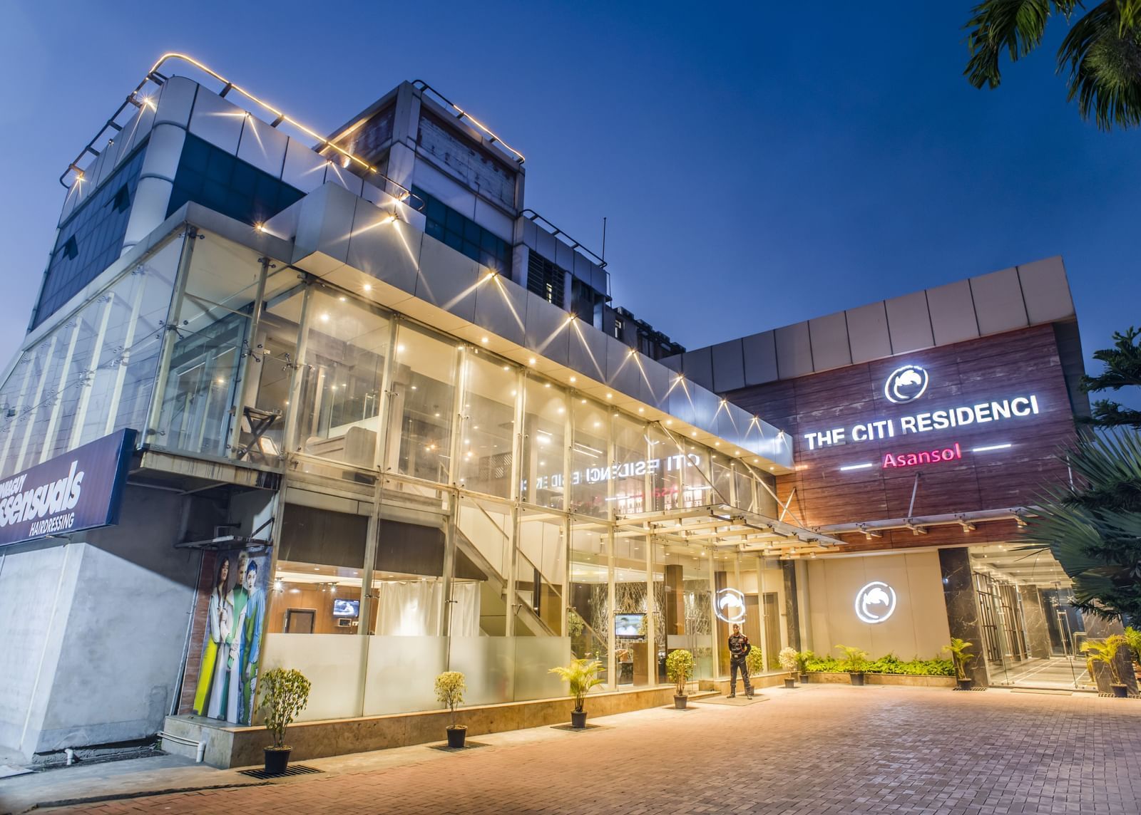 The exterior of The Citi Residenci Hotel, Asansol, at dusk with lights on.