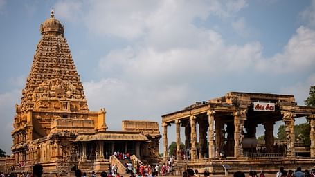 Devotees gathered at a temple with a clear blue sky in the background.