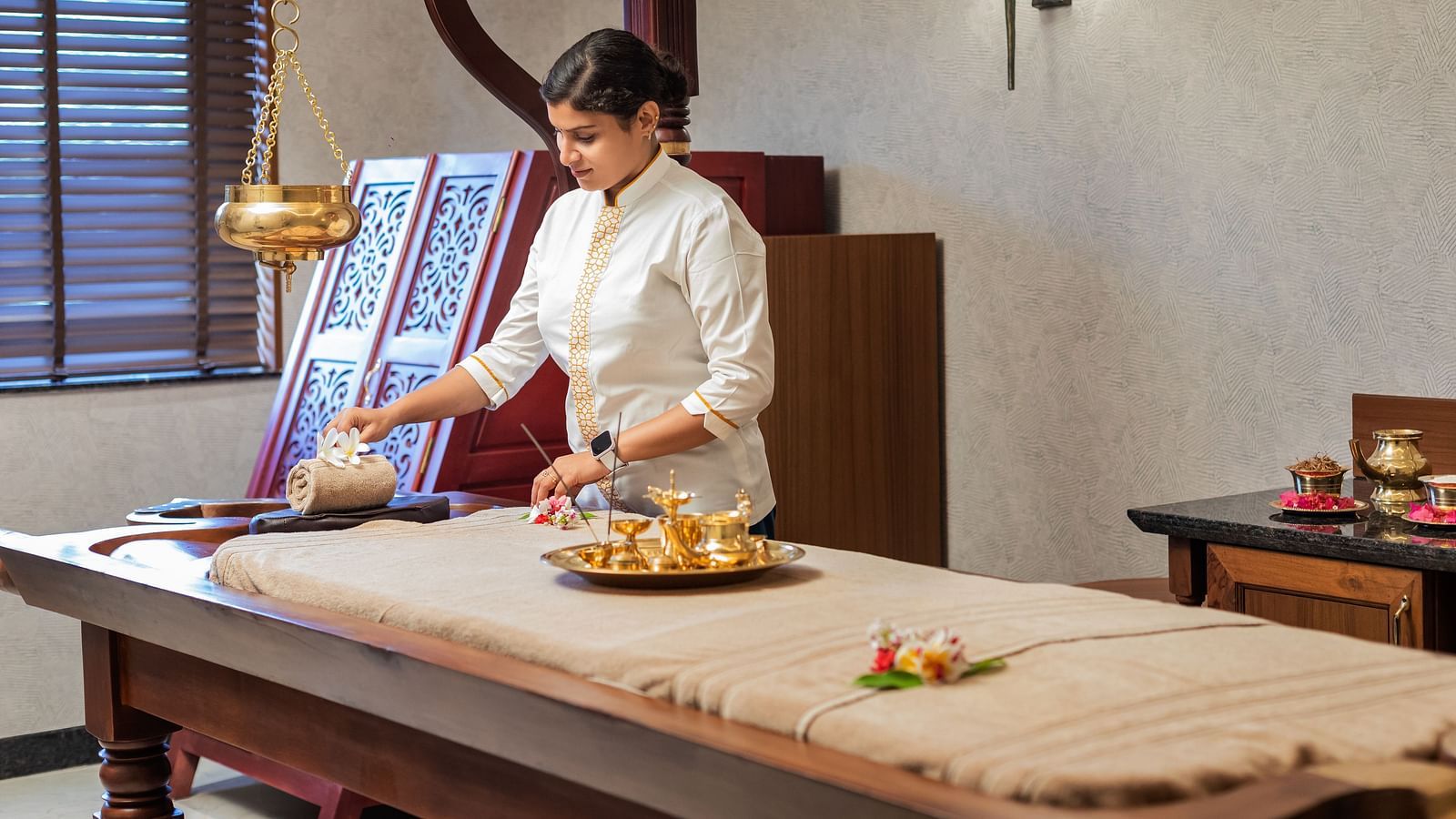 A spa room where a woman can be seen making arrangement for a session - Gamyam Retreat