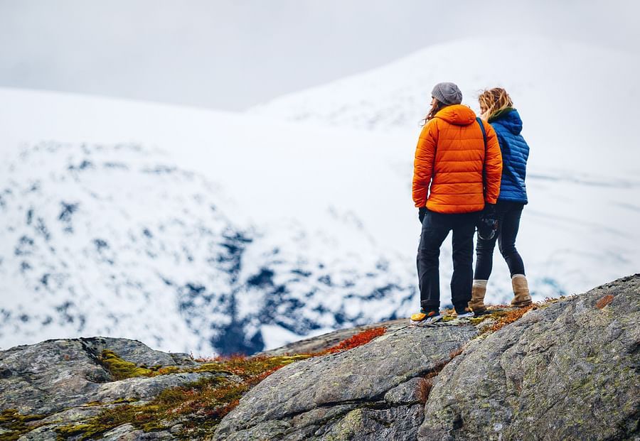 Couple standing on a snow clad cliff