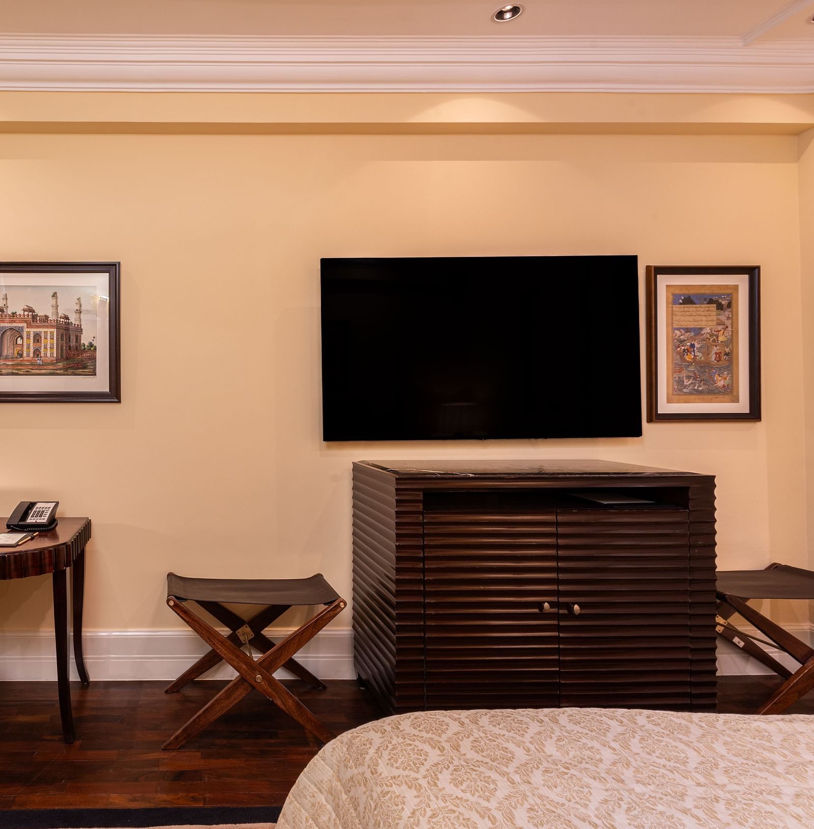 image of the work desk with a cushioned chair and the wall mounted tv with a cabinet  - The Claridges New Delhi