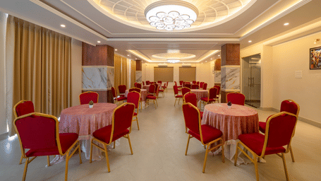 A banquet setup with round tables and chairs for events at Perfectstayz Premium Kaashin, Varanasi.