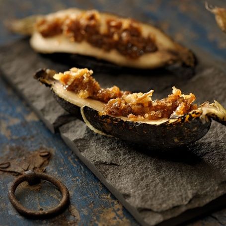 Baked banana with sweet filling on a slate dish.