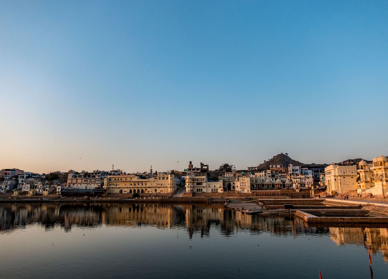 A serene view of a lake reflecting buildings at sunset or sunrise.
