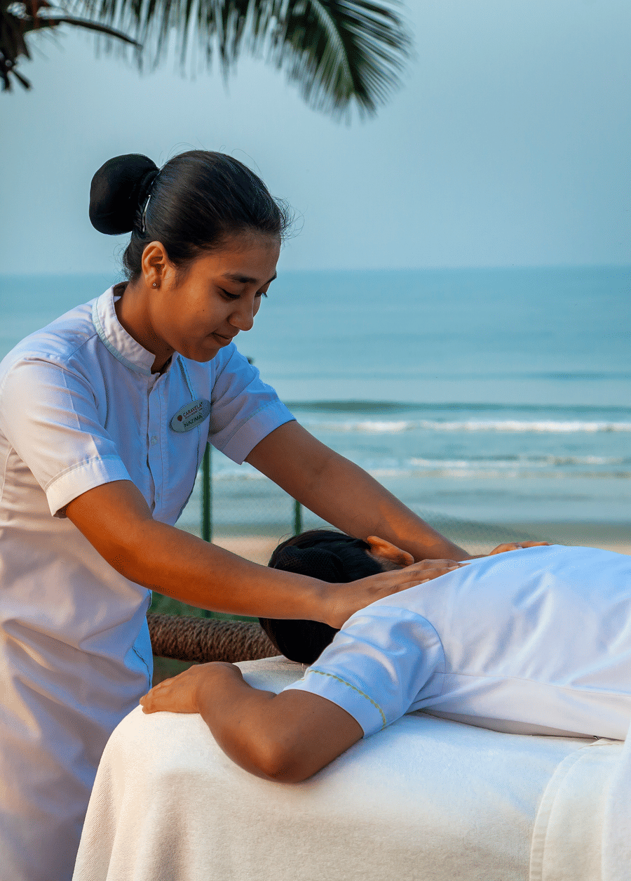 a masseuse giving a back massage by the beach - Caravela Beach Resort Goa