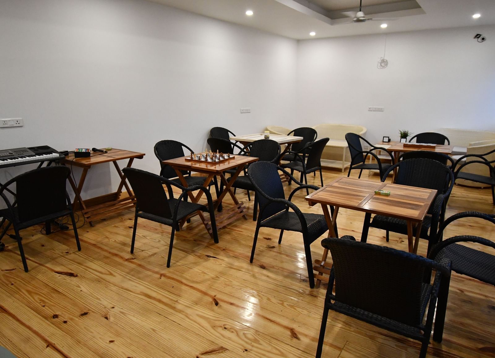 image of the indoor games area with chairs arranged around the board games with wooden flooring at the tattva, joshimath