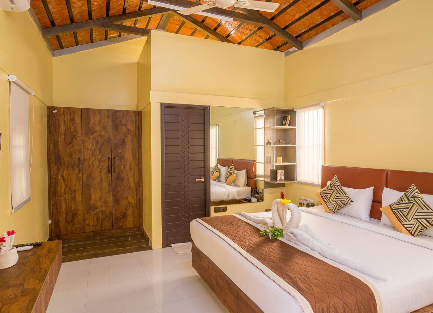 Well-lit bedroom with twin beds and rustic ceiling – Nirantara Resort & Spa