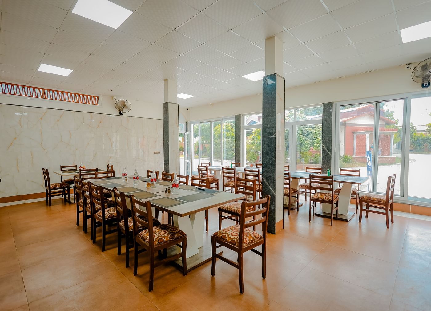 A dining area or event space with long tables and chairs at Nirantara Resort & Spa.