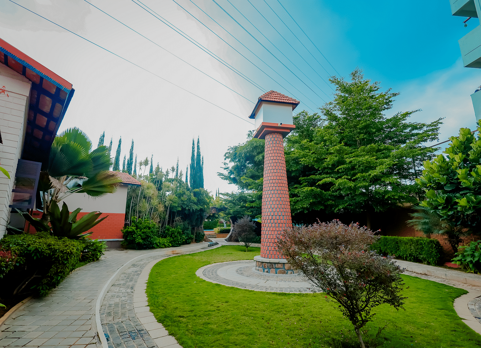 The grounds of Nirantara Resort & Spa with a clock tower, landscaped gardens, and pathways.