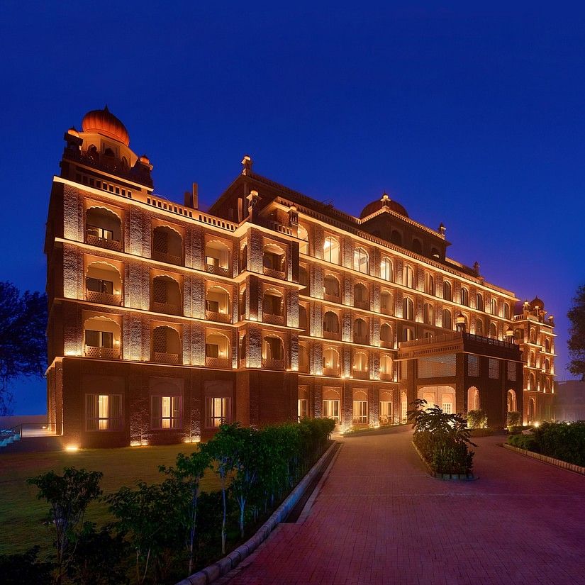 An evening view of our hotel in Amritsar illuminated warm yellow lights and dark blue sky in the background - Sarovar Premiere Amritsar