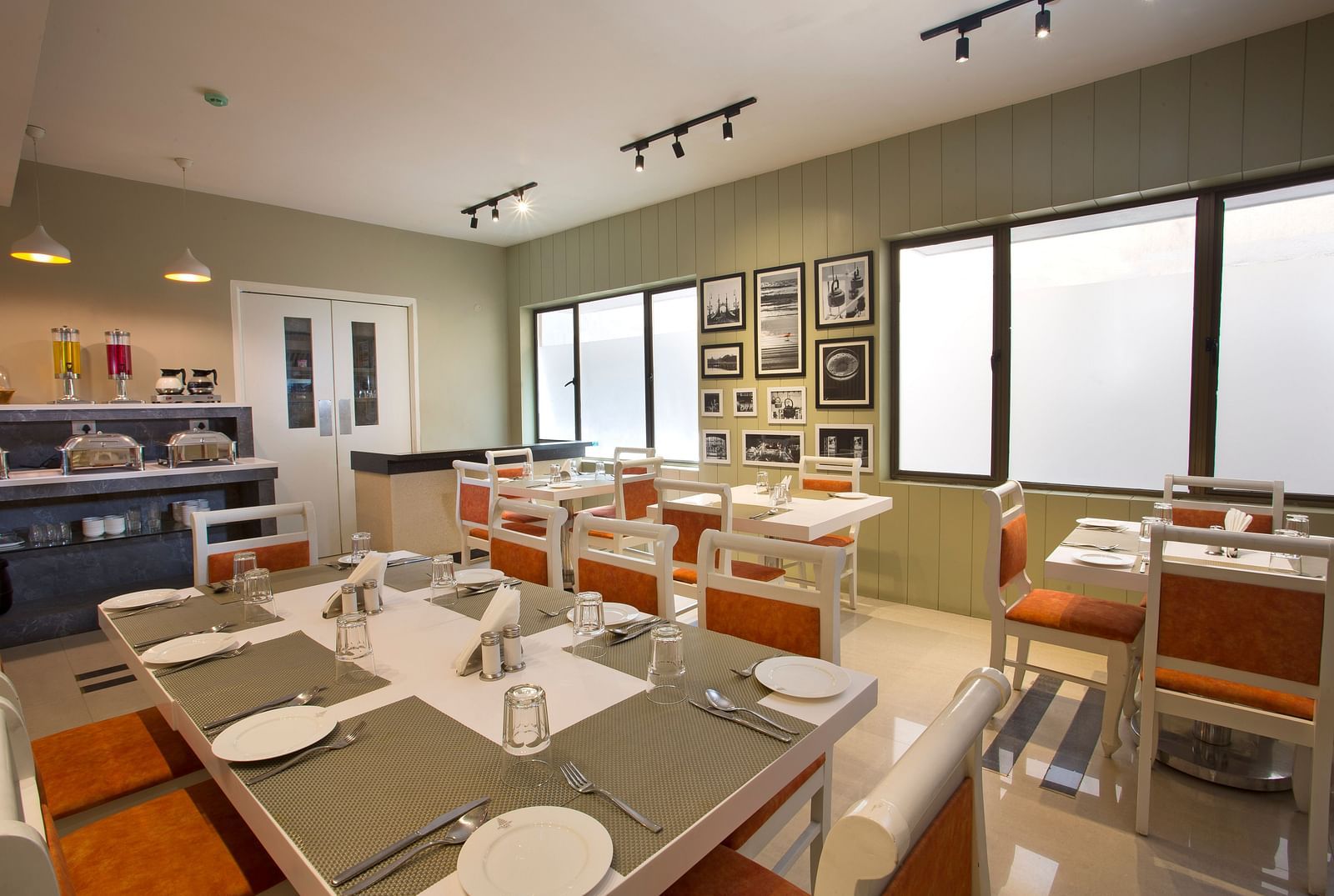 A contemporary dining area with set tables, modern lighting and black and white wall photographs  - Hotel Langford Keys by TGI, Shanti Nagar