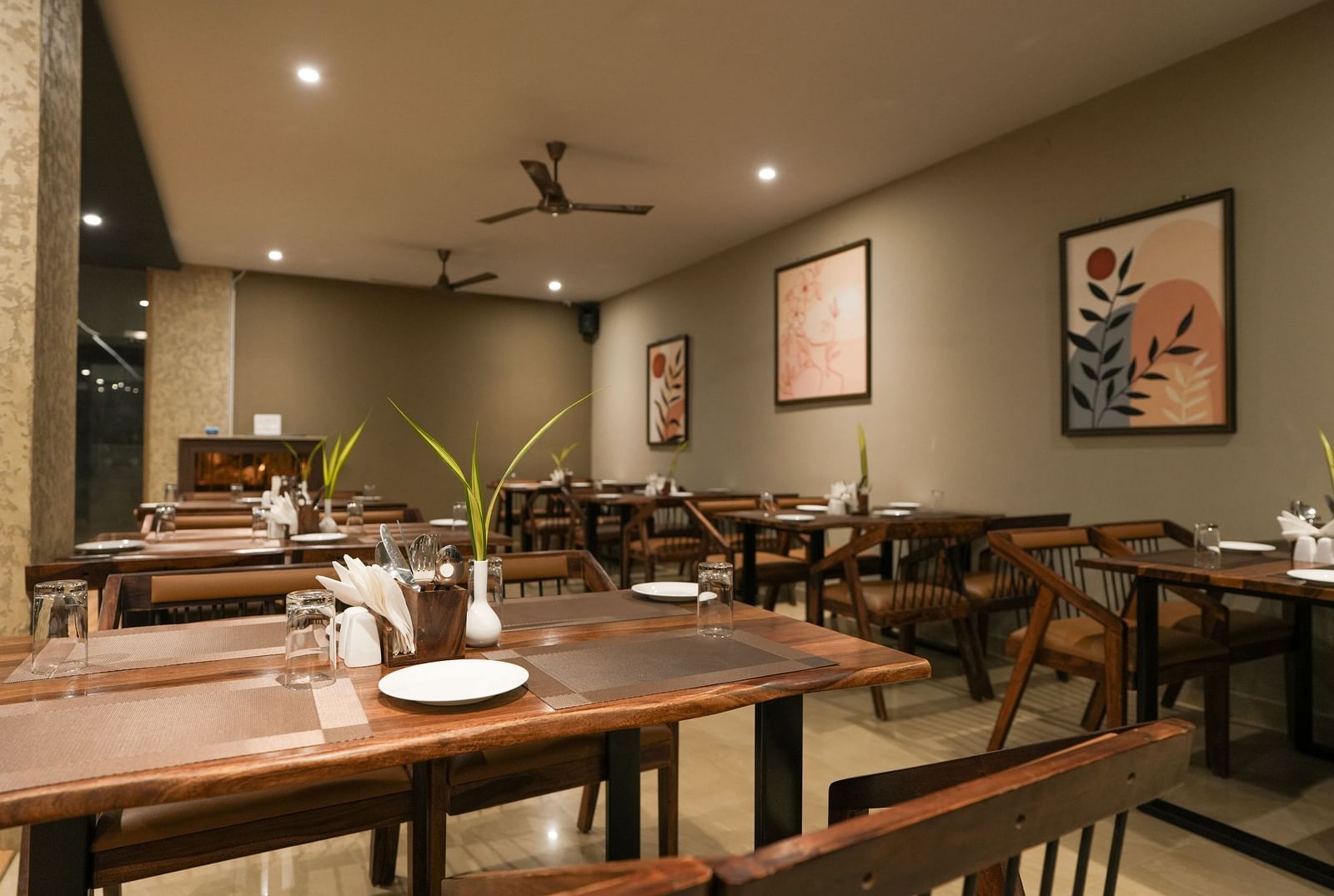 A restaurant view with ceiling fans, spotlights, and wooden dining furniture at TGI Livancia Hillside, JC Nagar, Mysore