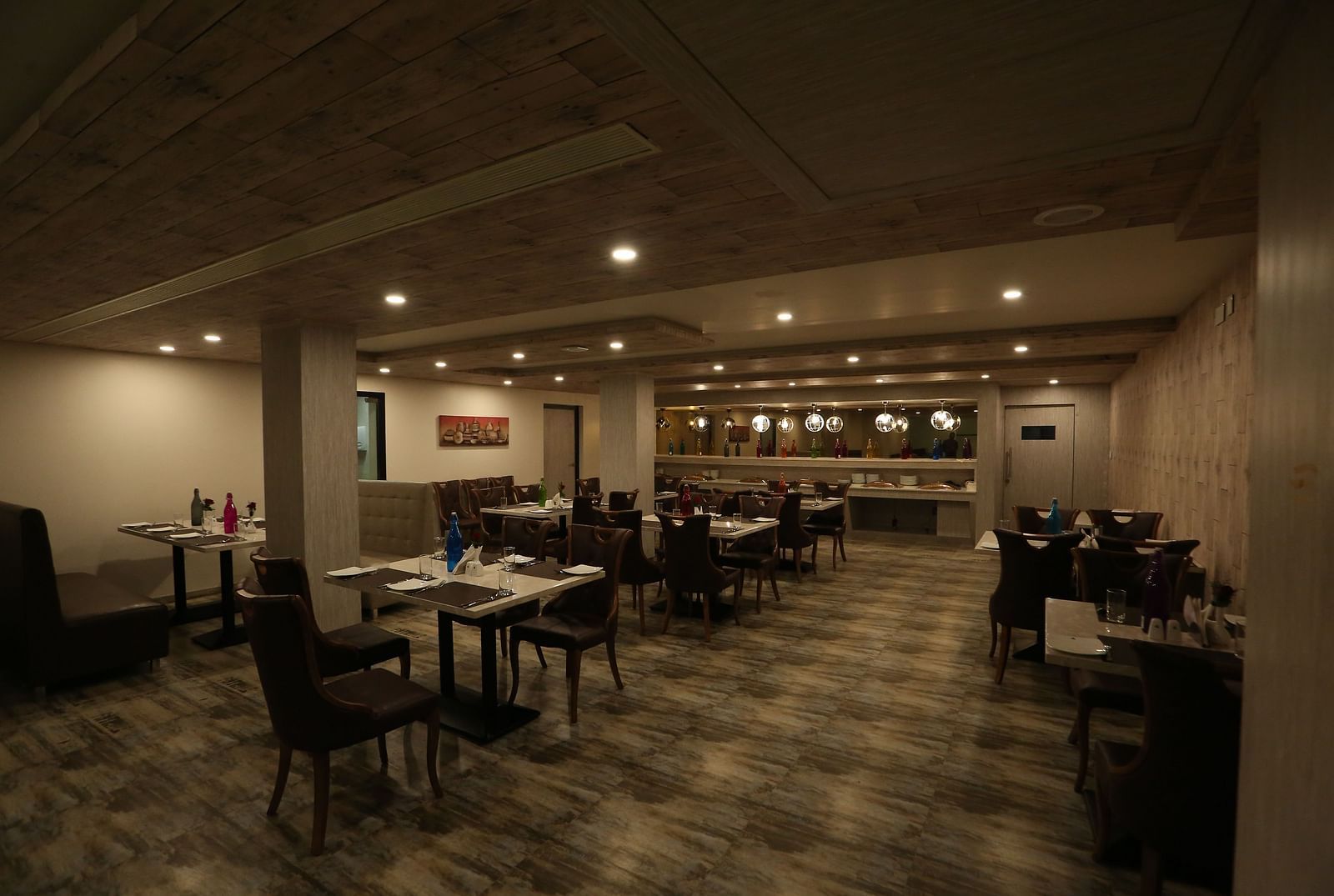 A restaurant with tables and chairs, designed with warm lighting and a cosy ambience - TGI SPS Grand, Coimbatore