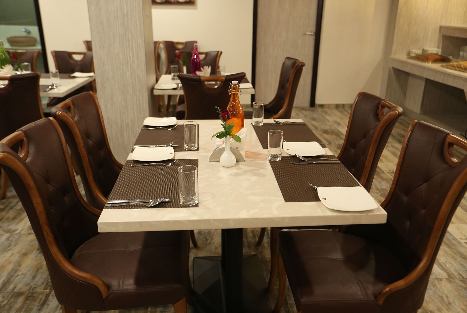 A dining area with set tables surrounded by chairs - TGI SPS Grand, Coimbatore