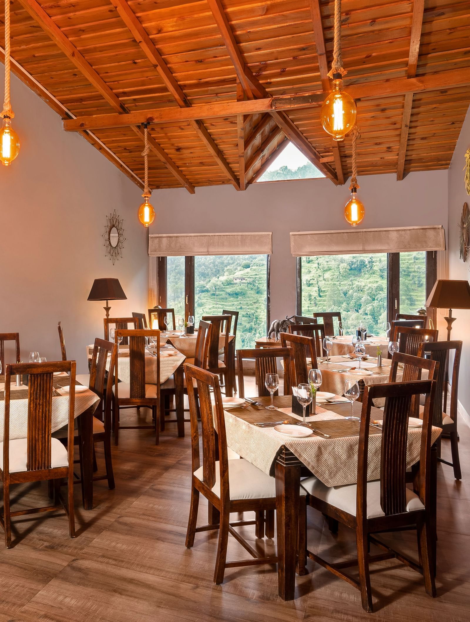 Rustic indoor dining area with wooden furniture and sloped ceiling, at BluSalzz Collection - Suvaasa Resort, Ramgarh.
