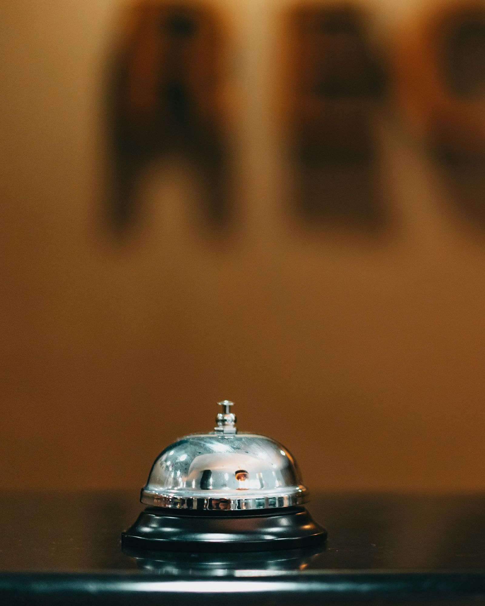 A polished service bell sits on a dark surface, suggesting attentive guest service at Lords Plaza Surat.