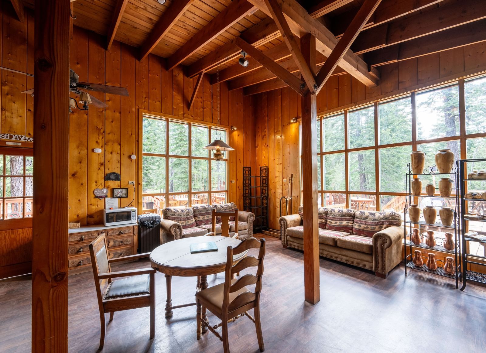 Cozy wood-paneled lounge area with large windows and rustic seating inside Kit Carson Lodge.
