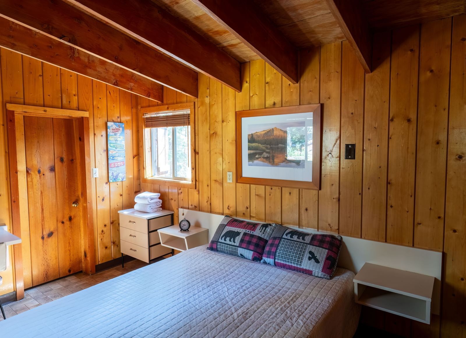 Cozy bedroom with large windows and cabin-style bedding at Kit Carson Lodge.